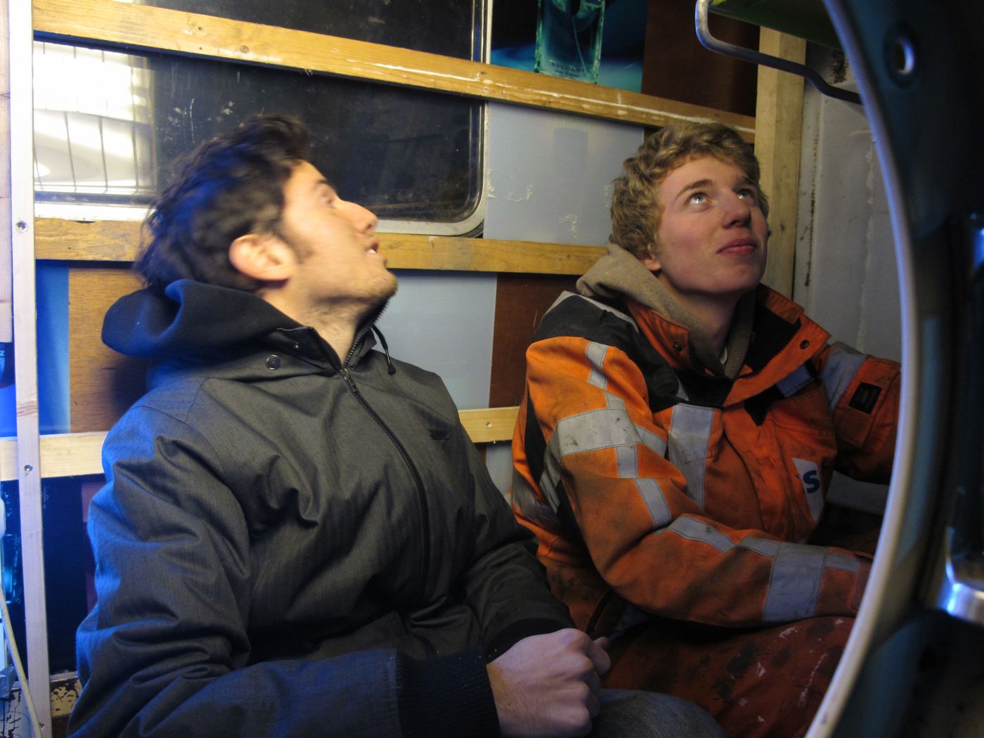 Two people sitting inside the house, looking out